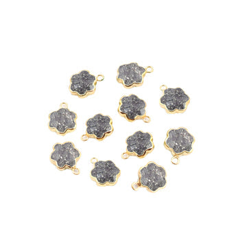 A set of two gold-colored, clover leaf-shaped black sunstone pendants.