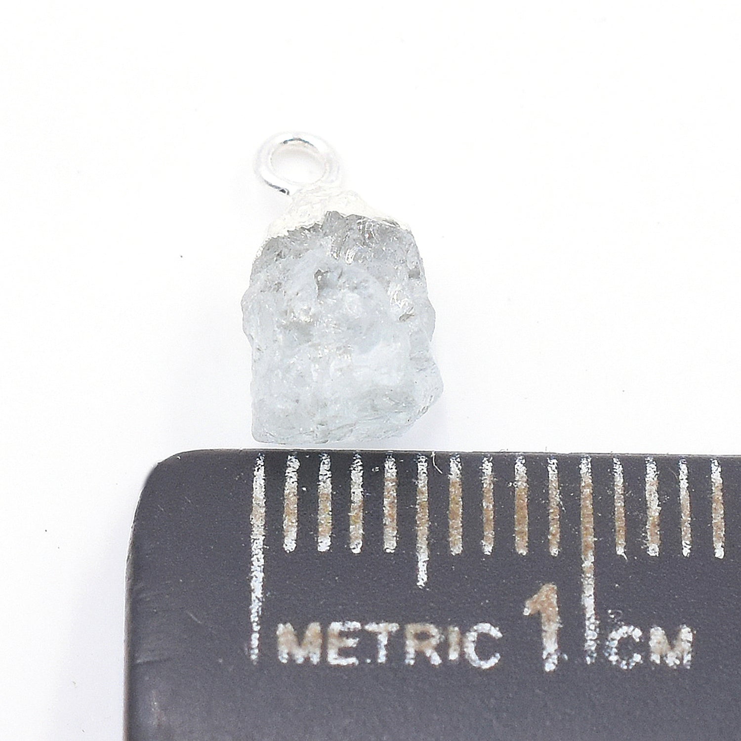 Vibrant aquamarine pendant shaped like an Rough