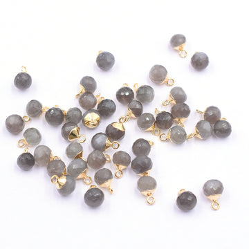Close up of a gray moonstone onion shaped pendant elegantly gold electroplated showcasing its shimmering surface
